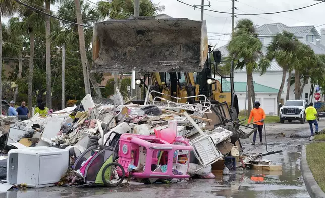 Salvage works remove debris from Hurricane Helene flooding along the Gulf of Mexico Monday, Oct. 7, 2024, in Clearwater Beach, Fla. Crews are working to remove the debris before Hurricane Milton approaches Florida's west coast. (AP Photo/Chris O'Meara)