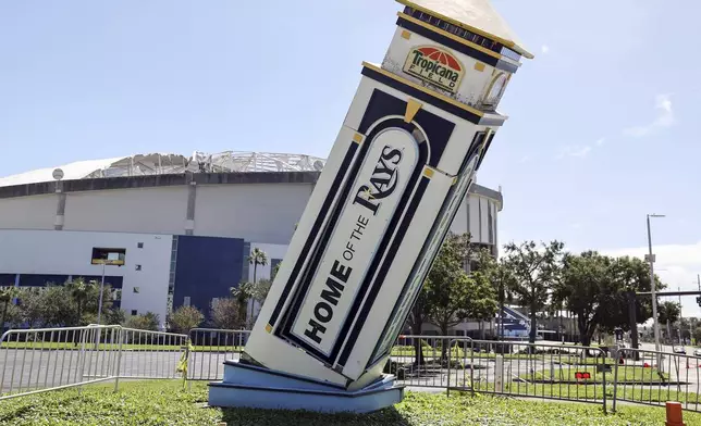 Signage and the roof of Tropicana Field damaged by winds from Hurricane Milton on Thursday, Oct. 10, 2024, in St. Petersburg, Fla. (AP Photo/Mike Carlson)