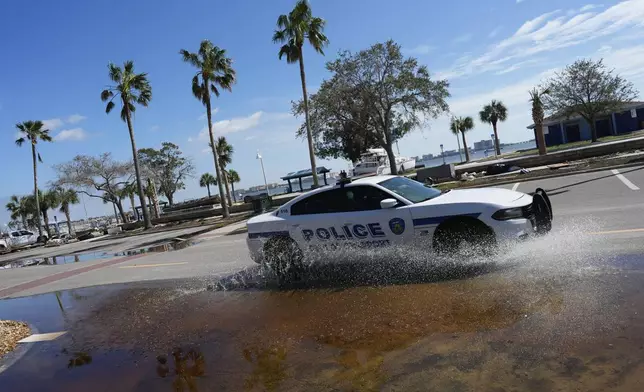 A police car patrols along a lightly flooded street following the passage of Hurricane Milton, in Gulfport, Fla., Thursday, Oct. 10, 2024. (AP Photo/Rebecca Blackwell)