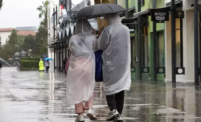 Tourists take in a last minute visit to Disney Springs entertainment complex before the arrival of Hurricane Milton Wednesday, Oct. 9, 2024, in Lake Buena Vista, Fla. (AP Photo/John Raoux)