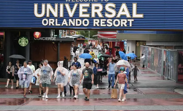 Tourists exit Universal Orlando Resort as they were closing early for the arrival of Hurricane Milton Wednesday, Oct. 9, 2024, in Orlando, Fla. (AP Photo/John Raoux)