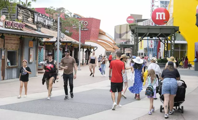 Calm weather greets tourists strolling past the various shops at the Disney Springs entertainment complex as Hurricane Milton threatens Florida, Tuesday, Oct. 8, 2024, in Lake Buena Vista, Fla. (AP Photo/John Raoux)