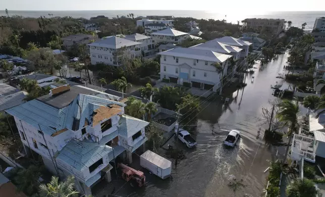 A truck drives down a flooded street in Siesta Key, Fla., following the passage of Hurricane Milton, Thursday, Oct. 10, 2024. (AP Photo/Rebecca Blackwell)