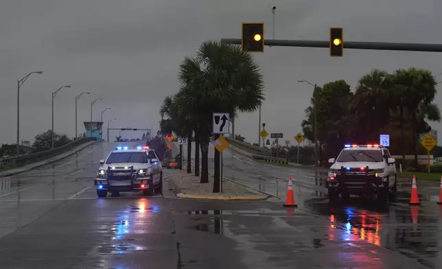 Police block off a bridge leading to the barrier island of St. Pete Beach, Fla., ahead of the arrival of Hurricane Milton, in South Pasadena, Fla., Wednesday, Oct. 9, 2024. (AP Photo/Rebecca Blackwell)