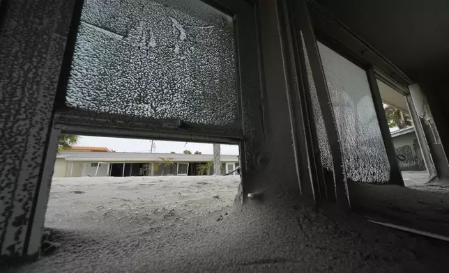 Several feet of sand fills condos at YCA Vacation Rentals, following the passage of Hurricane Milton, in Venice, Fla., Friday, Oct. 11, 2024. (AP Photo/Rebecca Blackwell)