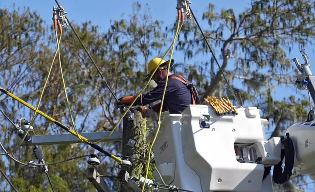 Pike Corporation linemen, of North Carolina, repair power lines damaged by Hurricane Milton Monday, Oct. 14, 2024, in Lithia, Fla. (AP Photo/Chris O'Meara)