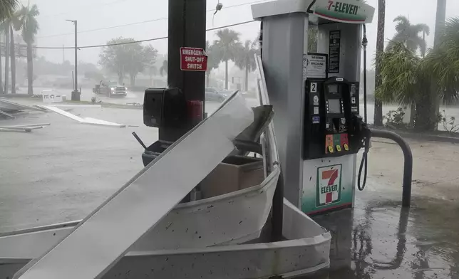 An apparent tornado caused by Hurricane Milton, tore the awning off a 7-Eleven convenient store, Wednesday, Oct. 9, 2024, in Cape Coral, Fla.(AP Photo/Marta Lavandier)