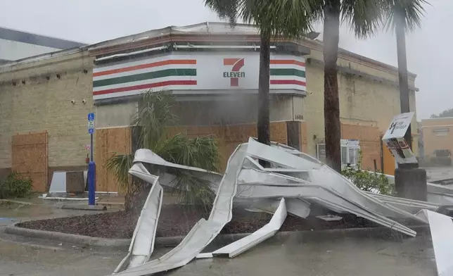 An apparent tornado caused by Hurricane Milton, tore the awning off a 7-Eleven convenient store, Wednesday, Oct. 9, 2024, in Cape Coral, Fla. (AP Photo/Marta Lavandier)