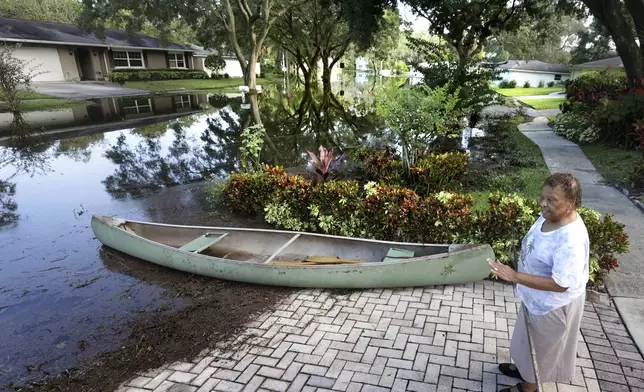 Spring Oaks resident Earline Gonzales talks about the rising waters from the Little Wekiva River in her flooded neighborhood in Altamonte Springs, Fla., Friday, Oct. 11, 2024. Central Florida rivers are forecast to rise in the coming days because of the excessive rainfall from Hurricane Milton. (Joe Burbank/Orlando Sentinel via AP)