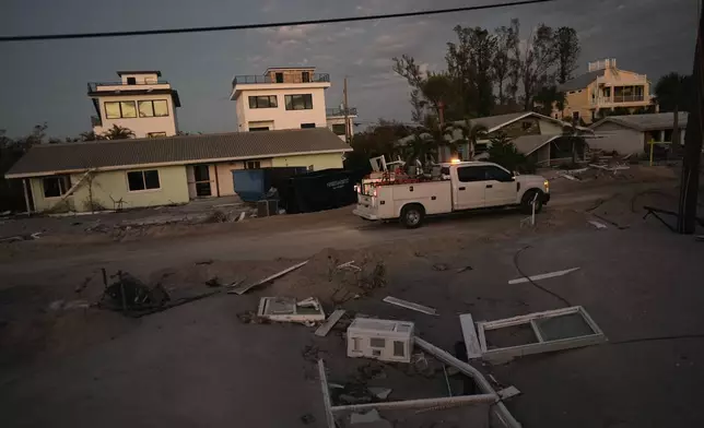 A county vehicle drives past damaged homes on Manasota Key, Fla., following the passage of Hurricane Milton, Saturday, Oct. 12, 2024. (AP Photo/Rebecca Blackwell)