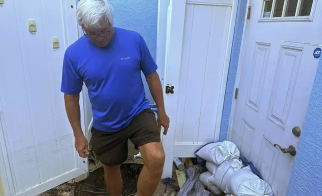 Don Glass stands his at his home, Saturday, Oct. 12, 2024, in Bradenton Beach, Fla., which saw flooding from Hurricane Helene and wind damage from Hurricane Milton two weeks later. (AP Photo/Russ Bynum)