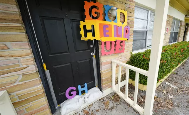 A message is seen outside of an apartment in the Davis Islands community of Tampa, Fla., as residents prepare for the arrival of Hurricane Milton, Tuesday, Oct. 8, 2024. (AP Photo/Julio Cortez)