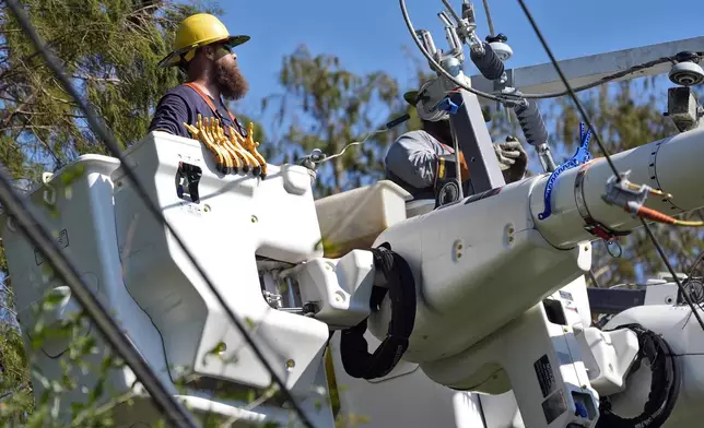 Pike Corporation linemen, of North Carolina, repair power lines damaged by Hurricane Milton Monday, Oct. 14, 2024, in Lithia, Fla. (AP Photo/Chris O'Meara)