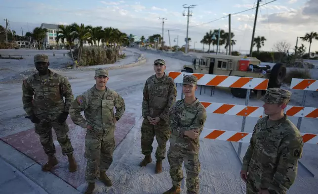 Florida National Guardsmen control access to a heavily damaged area of Manasota Key, Fla., following the passage of Hurricane Milton, Saturday, Oct. 12, 2024. (AP Photo/Rebecca Blackwell)