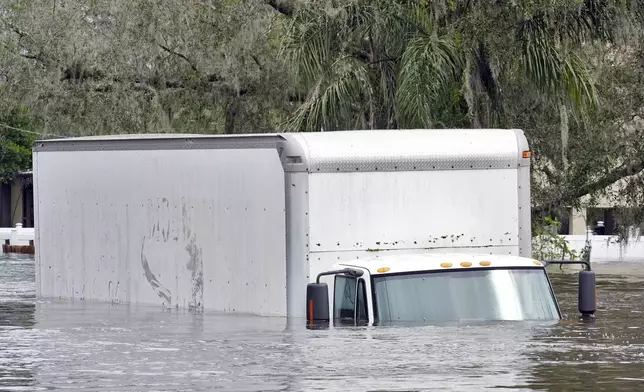 A box truck sits in floodwaters caused by Hurricane Milton along the Alafia river Friday, Oct. 11, 2024, in Lithia, Fla. (AP Photo/Chris O'Meara)