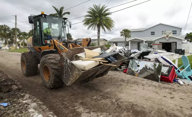 Contractors with the City of New Port Richey help clean debris left by Hurricane Helene in preparation for Hurricane Milton on Monday, Oct. 7, 2024, in New Port Richey, Fla. (AP Photo/Mike Carlson)