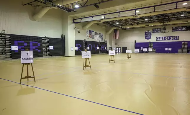 Flooring and signage is laid out at River Ridge High School as they ready the school for use as a shelter in preparation for Hurricane Milton on Monday, Oct. 7, 2024, in New Port Richey, Fla. (AP Photo/Mike Carlson)