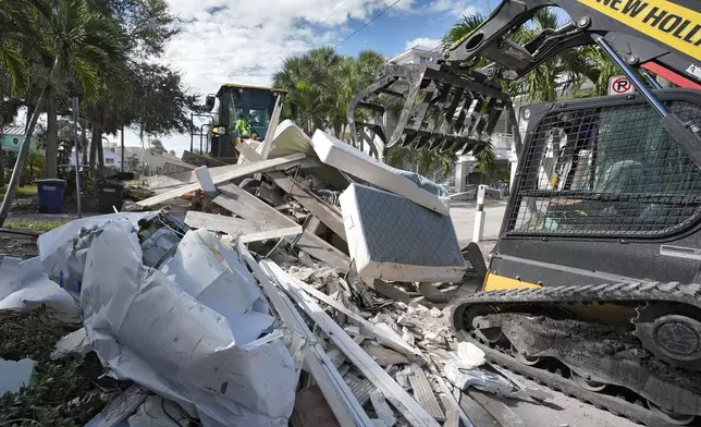 Salvage crews continue to clean up household debris, damaged in Hurricane Helene, Tuesday, Oct. 8, 2024, in Clearwater Beach, Fla., ahead of the possible landfall from Hurricane Milton. (AP Photo/Chris O'Meara)