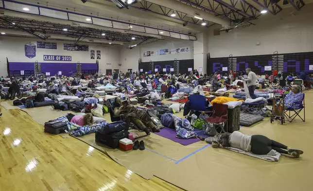 A view of some of the 700 evacuees in the gymnasium in shelter at River Ridge Middle/High School in preparation for Hurricane Milton on Wednesday, Oct. 9, 2024, in New Port Richey, Fla. (AP Photo/Mike Carlson)