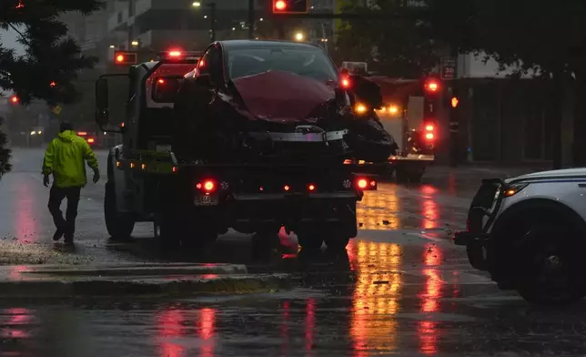 A tow truck responds following a traffic accident between a car and a fire truck returning from a call, on near-deserted streets in downtown Tampa, Fla., during the approach of Hurricane Milton, Wednesday, Oct. 9, 2024. (AP Photo/Rebecca Blackwell)