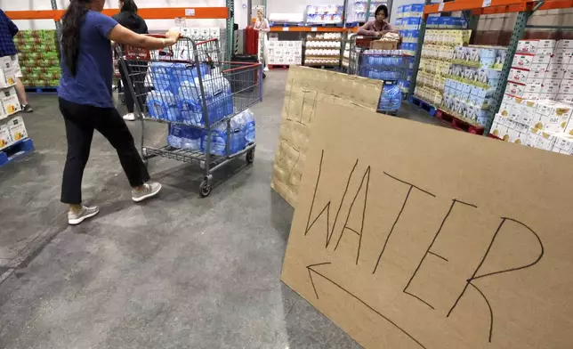 Shoppers load cases of water at the Costco at Costco, Monday, Oct. 7, 2024, in Altamonte Springs, Fla., as residents prepare for the impact of approaching Hurricane Milton. (Joe Burbank/Orlando Sentinel via AP)