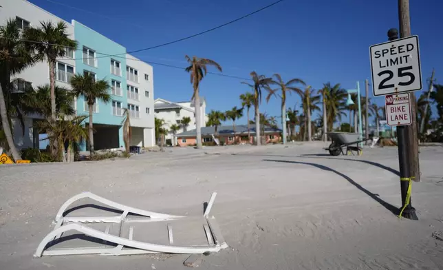 Sand covers a remaining stretch of the main road in southern Manasota Key, in Englewood, Fla., as Charlotte County crews work to clear it, following the passage of Hurricane Milton, Sunday, Oct. 13, 2024. (AP Photo/Rebecca Blackwell)