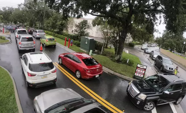 Cars wait in line to get into the parking lot for gas at Costco, Monday, Oct. 7, 2024, in Altamonte Springs, Fla., as residents prepare for the impact of approaching Hurricane Milton. (Joe Burbank/Orlando Sentinel via AP)