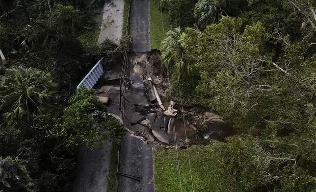 A bridge going over a small creek is seen damaged by Hurricane Milton, Friday, Oct. 11, 2024, in Riverview, Fla. The road is the only access point into a community. (AP Photo/Julio Cortez)