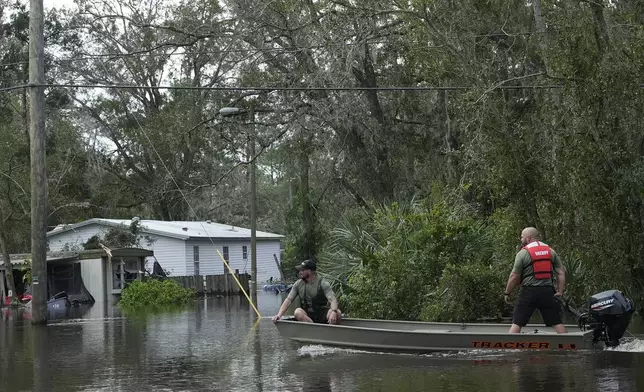 Members of the Hillsborough County Sheriff's office drive a boat through floodwaters from Hurricane Milton near the Alafia River Friday, Oct. 11, 2024, in Lithia, Fla. (AP Photo/Chris O'Meara)