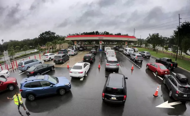 Cars wait in line to get into the parking lot for gas at Costco, Monday, Oct. 7, 2024, in Altamonte Springs, Fla., as residents prepare for the impact of approaching Hurricane Milton. (Joe Burbank/Orlando Sentinel via AP)