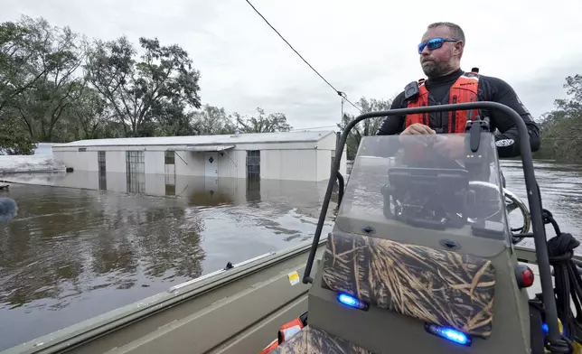 Hillsborough County Sheriff's Master Deputy Robert Unger checks out flooded home from the effects of Hurricane Milton along the Alafia river Friday, Oct. 11, 2024, in Lithia, Fla. (AP Photo/Chris O'Meara)