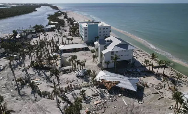 Buildings damaged in Hurricane Milton are seen, along with a water channel opened by the storm, top, cutting off access to much of Stump Pass Beach state park, on the southern end of Manasota Key in Englewood, Fla., Sunday, Oct. 13, 2024. (AP Photo/Rebecca Blackwell)