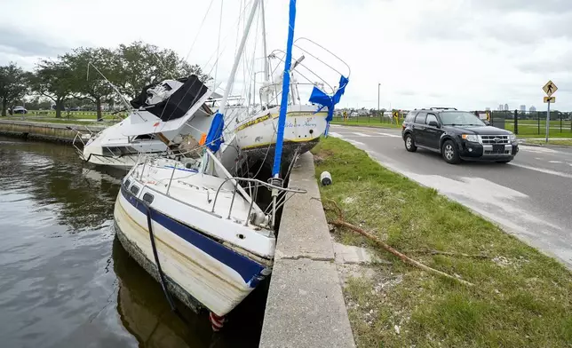 Boats are piled on the shore of the Davis Islands Yacht Basin in the Davis Islands community of Tampa, Fla., the day after Hurricane Milton hit the region, Thursday, Oct. 10, 2024. (AP Photo/Julio Cortez)