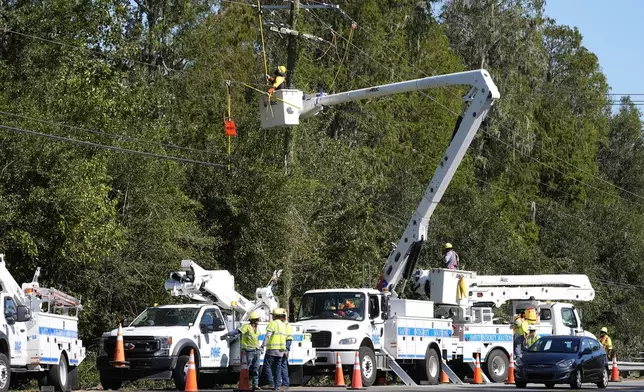 Pike Corporation linemen, of North Carolina, repair electricity damaged by Hurricane Milton Monday, Oct. 14, 2024, in Lithia, Fla. (AP Photo/Chris O'Meara)