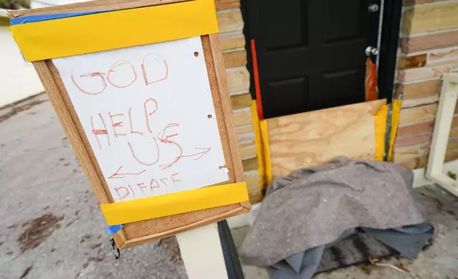 A message is seen outside of an apartment in the Davis Islands community of Tampa, Fla., as residents prepare for the arrival of Hurricane Milton, Tuesday, Oct. 8, 2024. (AP Photo/Julio Cortez)