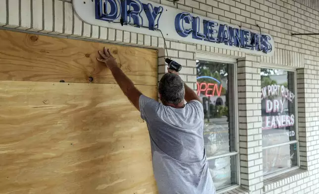 Jay McCoy puts up plywood in preparation for Hurricane Milton on Monday, Oct. 7, 2024, in New Port Richey, Fla. (AP Photo/Mike Carlson)