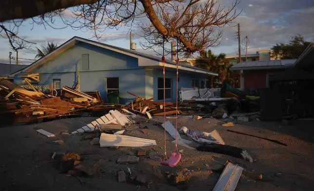 A child's swing still hangs on a tree, surrounded by debris from homes destroyed by Hurricane Milton, on Manasota Key, Fla., Saturday, Oct. 12, 2024. (AP Photo/Rebecca Blackwell)