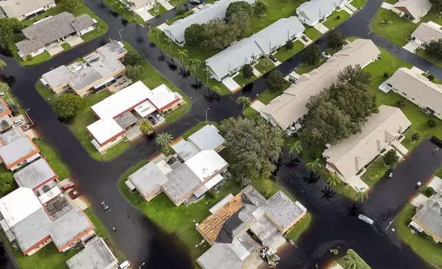 Waters rise in Pasco County neighborhoods as intense rain from Hurricane Milton caused the Anclote River to flood, Friday, Oct. 11, 2024, in New Port Richey, Fla. (AP Photo/Mike Carlson)