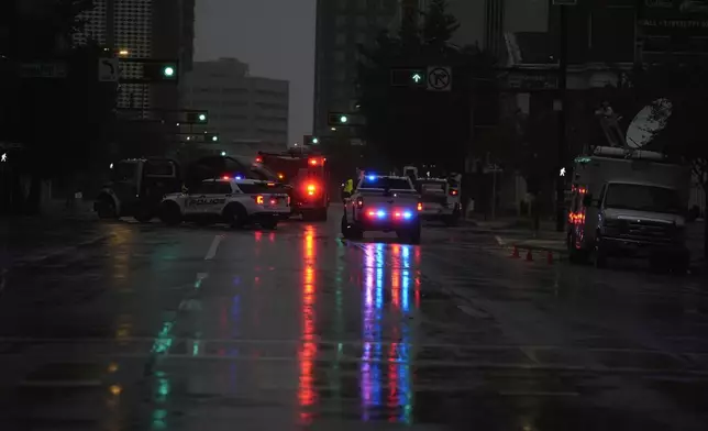 Police respond to a traffic accident between a car and a fire truck returning from a call, on near-deserted streets in downtown Tampa, Fla., during the approach of Hurricane Milton, Wednesday, Oct. 9, 2024. (AP Photo/Rebecca Blackwell)