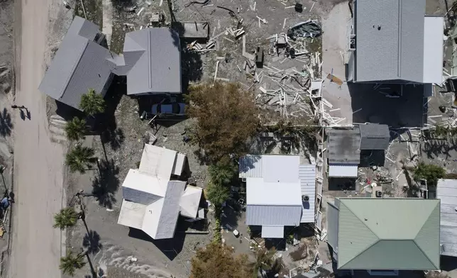 Three houses which shifted off their foundations, left, are seen from above following Hurricane Milton, on Manasota Key, in Englewood, Fla., Sunday, Oct. 13, 2024. (AP Photo/Rebecca Blackwell)