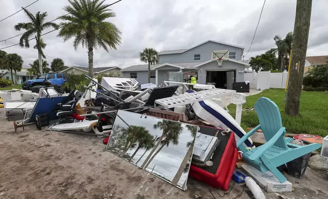 Contractors with the City of New Port Richey help clean debris left by Hurricane Helene in preparation for Hurricane Milton on Monday, Oct. 7, 2024, in New Port Richey, Fla. (AP Photo/Mike Carlson)