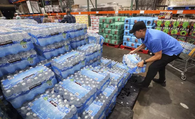 A customer grabs a case of water at the Costco in Altamonte Springs, Fla., Monday, Oct. 7, 2024, as residents prepare for the impact of Hurricane Milton. (Joe Burbank/Orlando Sentinel via AP)