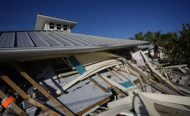 A property owner who preferred not to give his name peers into the remains of the second floor unit where he lived with his wife while renting out the other units, on Manasota Key, in Englewood, Fla., following the passage of Hurricane Milton, Sunday, Oct. 13, 2024. (AP Photo/Rebecca Blackwell)