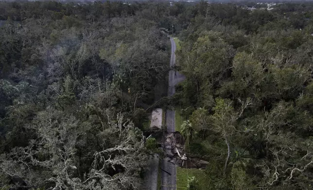 A bridge going over a small creek is seen damaged by Hurricane Milton, Friday, Oct. 11, 2024, in Riverview, Fla. The road is the only access point into a community. (AP Photo/Julio Cortez)