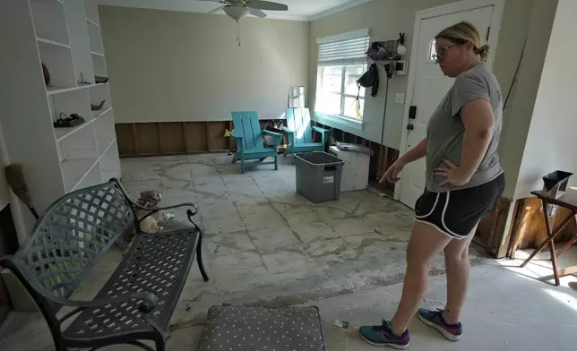 Kat Robinson-Malone points to where flood waters from the effects of Hurricane Milton seeped through their floor's foundation Sunday, Oct. 13, 2024, in Tampa, Fla. (AP Photo/Chris O'Meara)