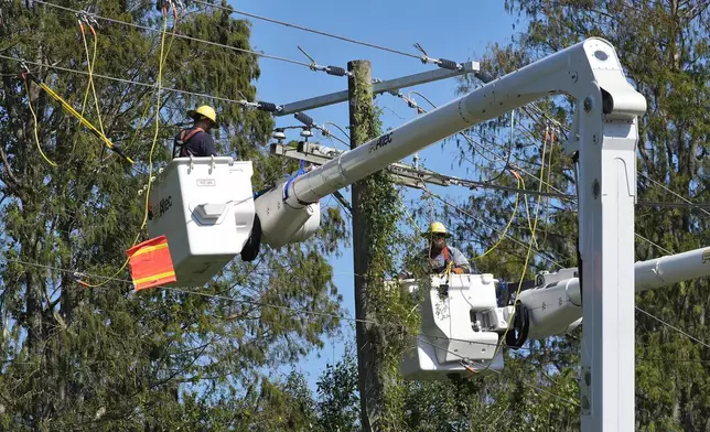 Pike Corporation linemen, of North Carolina, repair power lines damaged by Hurricane Milton Monday, Oct. 14, 2024, in Lithia, Fla. (AP Photo/Chris O'Meara)