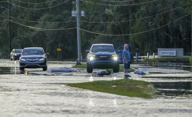 A man negotiates driving through flood waters into a community surrounded with floodwaters the morning after Hurricane Milton hit the region, Thursday, Oct. 10, 2024, in Tampa, Fla. (AP Photo/Julio Cortez)