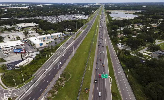 In this image taken with a drone, traffic flows eastbound along Interstate 4 as residents continue to follow evacuation orders ahead of Hurricane Milton, Tuesday, Oct. 8, 2024, in Tampa, Fla. (AP Photo/Julio Cortez)