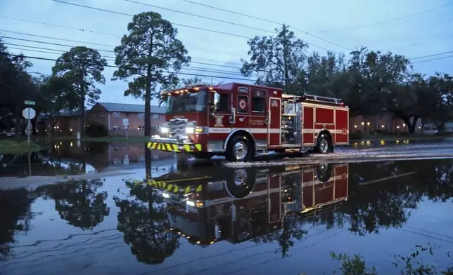 A firetruck drives through a flooded street due to Hurricane Milton in St. Petersburg, Fla., Thursday, Oct. 10, 2024. (Tampa Bay Times via AP)