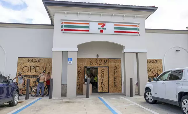 A store boards up but remains open in preparation for Hurricane Milton on Tuesday, Oct. 8, 2024, in New Port Richey, Fla. (AP Photo/Mike Carlson)